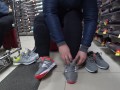 Foot fetish in a public shoe store. Fat legs try on sneakers.