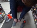 Foot fetish in a public shoe store. Fat legs try on sneakers.