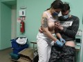 Медсестра помогает донору сдать сперму в подсобке.