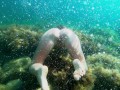 Голая девушка ныряет в океане и показывает свою киску