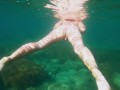 Голая девушка ныряет в океане и показывает свою киску