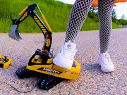 Big excavator is destroyed kicked, trampled, crushed, smashed, crushed, broken plastic car, crush