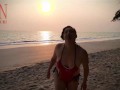 Nice lady at lonely nudist beach. Red swimsuit. Red bikini. Coconut