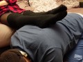 A slave in a collar is kneeling legs in black socks and tights