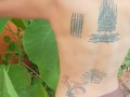 Slave May is showing her tattoos next to the swimming pool