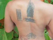 Slave May is showing her tattoos next to the swimming pool