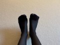 Sexy legs and feet in black nylon pantyhose