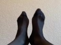 Sexy legs and feet in black nylon pantyhose