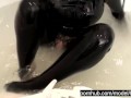 Blonde girl in black rubber catsuit in bathroom relaxes in wet latex and peeing in the bathtub