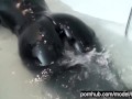 Blonde girl in black rubber catsuit in bathroom relaxes in wet latex and peeing in the bathtub