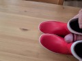 Cumming on her red rubberboots