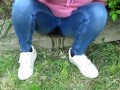 Pissing jeans in public street in sunny day