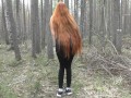 Redhead girl with long hair walking in the park