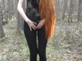 Redhead girl with long hair walking in the park