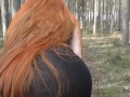 Redhead girl with long hair walking in the park