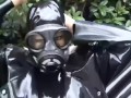 Latex girl full in black rubber and Gasmask chill outs outdoor in garden in a heavy rubber hammock