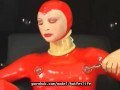 Sexy girl encased in red rubber catsuit loves medical games with mouth spreader and nipple clamps