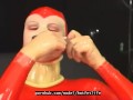 Sexy girl encased in red rubber catsuit loves medical games with mouth spreader and nipple clamps