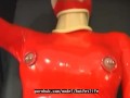 Sexy girl encased in red rubber catsuit loves medical games with mouth spreader and nipple clamps