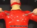 Sexy girl encased in red rubber catsuit loves medical games with mouth spreader and nipple clamps