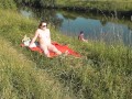 Riverside naked milf sunbathing is not shy about random fisher. Outdoors. Wild beach. Public nudity