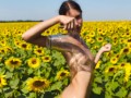 Fertility goddess caresses her pussy in a sunflower field