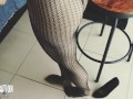 Shoe dangling with fishnets and black high heels