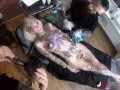 Sascha plays with Amber Luke while she gets tattooed