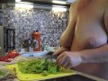Housewife with big saggy tits crumbles salad in the kitchen.