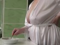 Mature MILF housewife with big natural tits is in the kitchen cooking scrambled eggs.