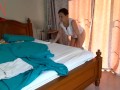 Nudist housekeeper Regina Noir makes the bedding in the bedroom. Naked maid. Naked housewife. c1