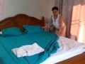 Nudist housekeeper Regina Noir makes the bedding in the bedroom. Naked maid. Naked housewife. c1