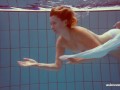 In the indoor pool, a stunning girl swims