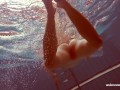 In the indoor pool, a stunning girl swims