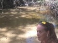 Cute long hair girl on her knees looking for shells to collect in popular spring creek