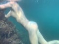 Голая девушка плавает в море и ласкает себя под водой