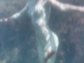 Голая девушка плавает в море и ласкает себя под водой