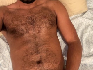 Hairy guy jerking off in bed quickly cums on himself