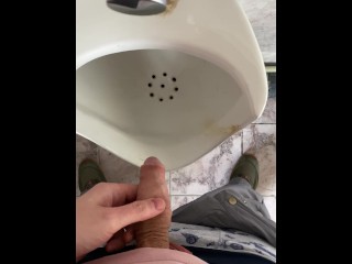 A man peeing in a public toilet, POV