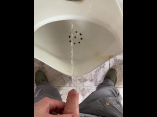 A man peeing in a public toilet, POV