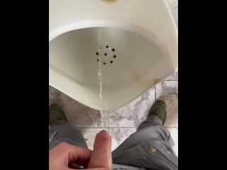 A man peeing in a public toilet, POV