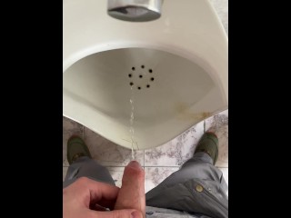 A man peeing in a public toilet, POV