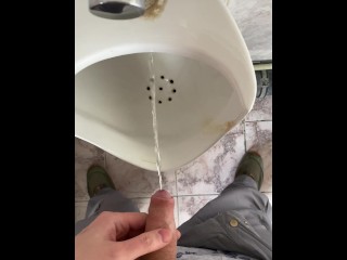 A man peeing in a public toilet, POV