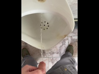 A man peeing in a public toilet, POV