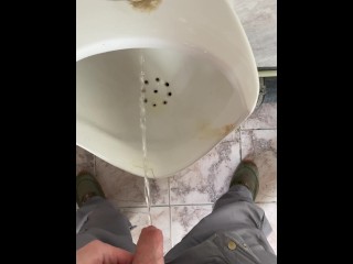 A man peeing in a public toilet, POV