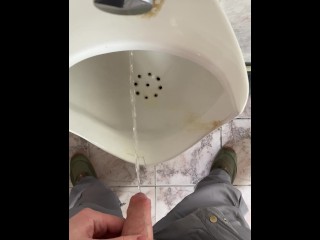 A man peeing in a public toilet, POV