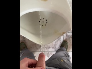 A man peeing in a public toilet, POV