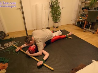 Girl in crotch rope predicament, tied in standing spread eagle and spanked