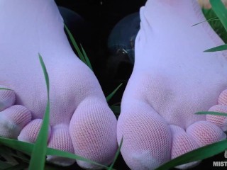 Goddess Feet in cute white socks with jeans on the spring grass field