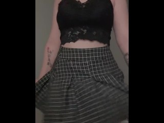 A girl in a mini skirt squeezes her ass.